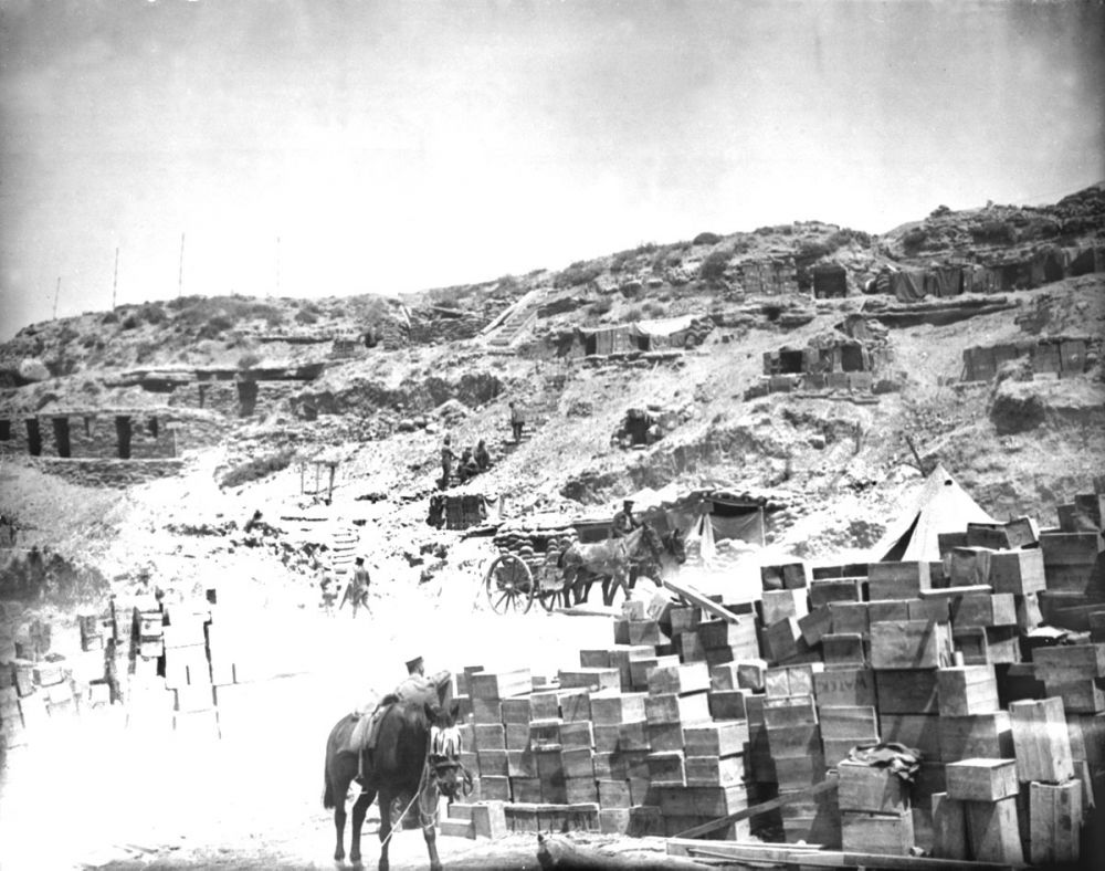 Dugouts in the hillside, and stores stacked on the beach at Lancashire Landing (W Beach), Cape Helles 1915.